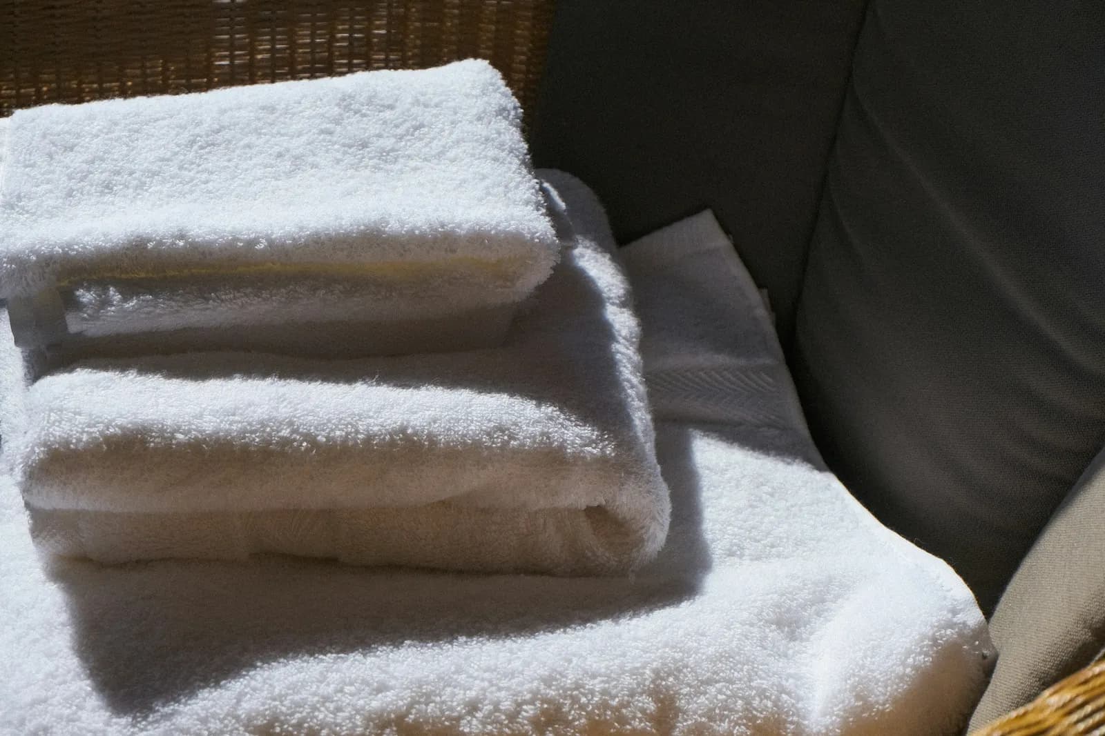 Clean white towels, folded and stacked on a chair