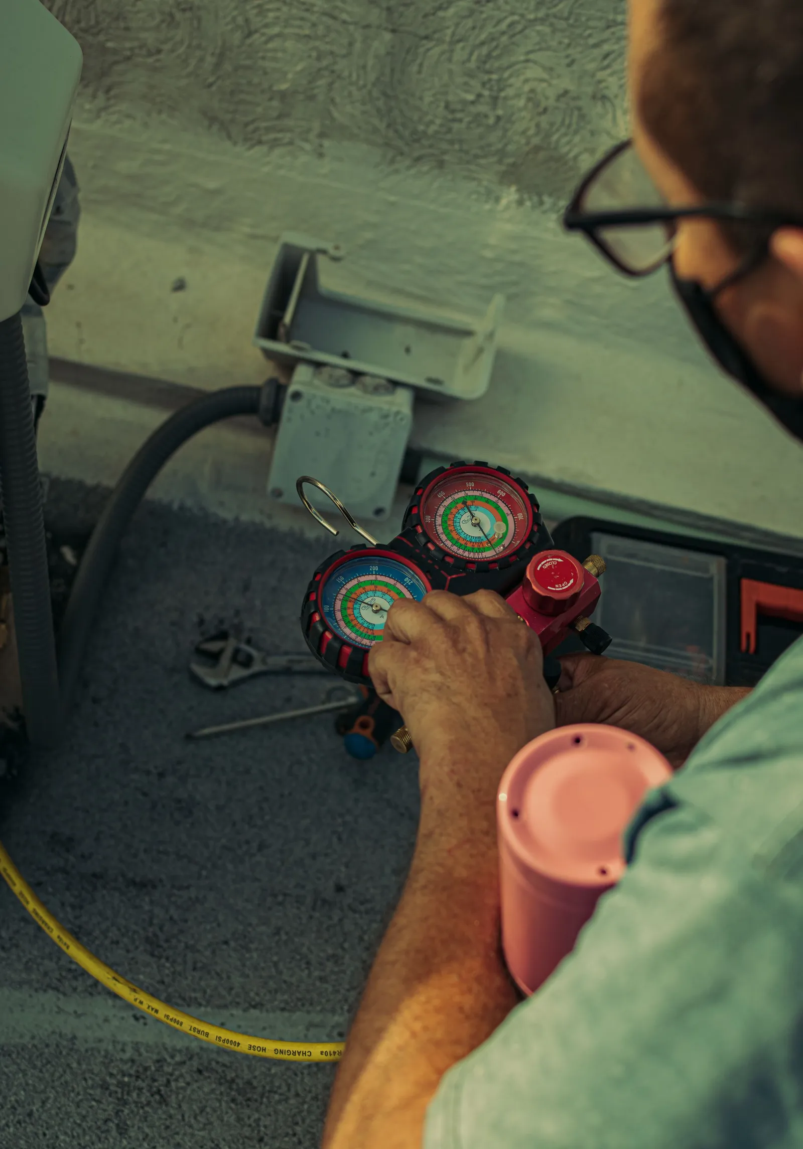 A technician holds a set of AC gauges by the unit