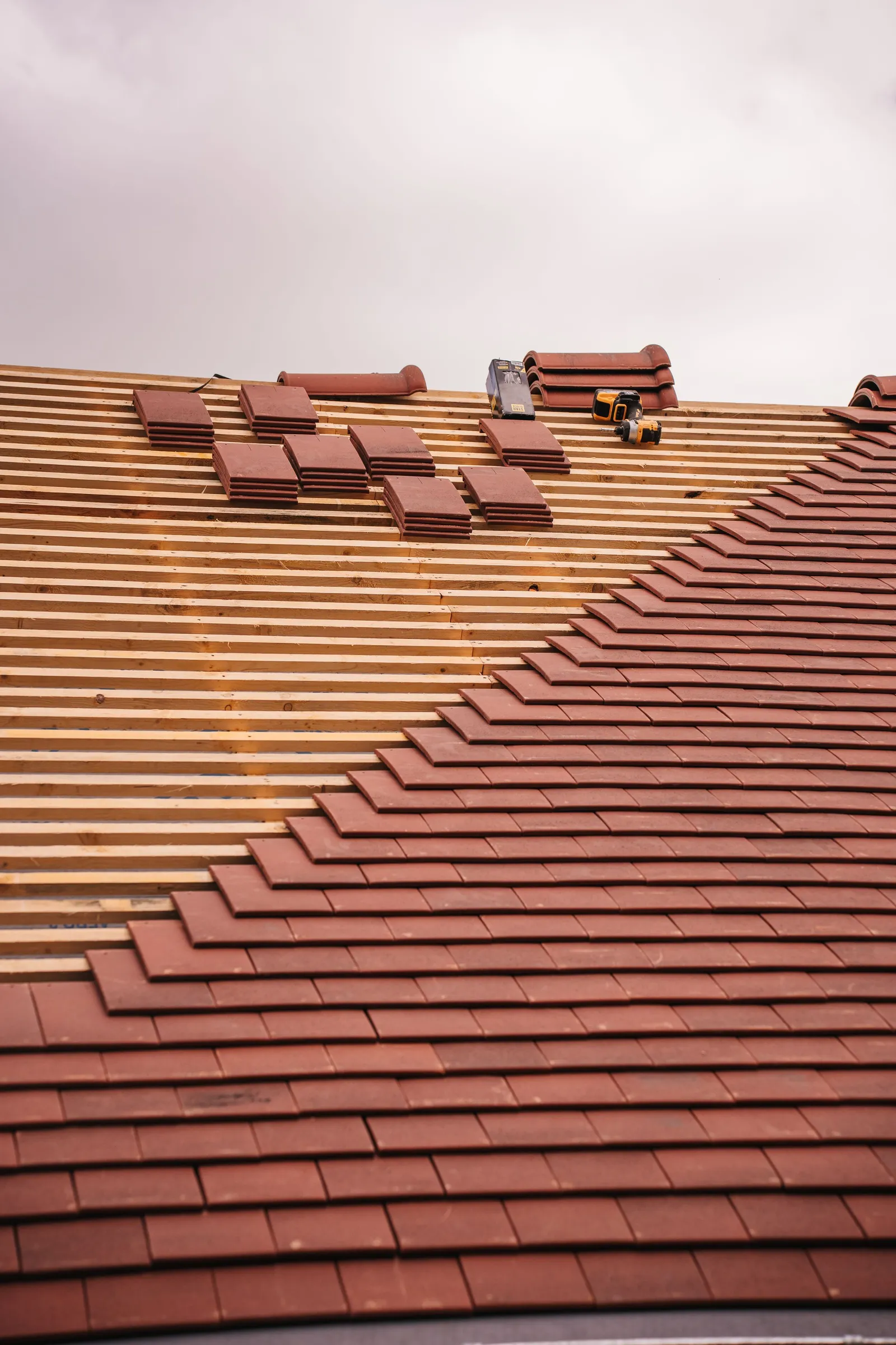 New clay tiles laid in rows, with more tiles stacked near the top